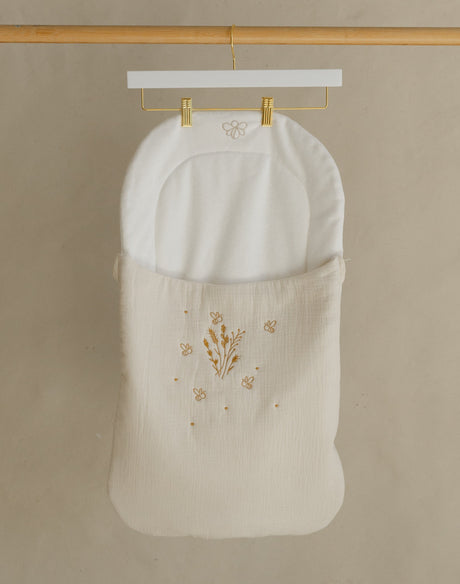 Wooden clothing rack with a white garment on a beige background