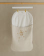 Wooden clothing rack with a white garment on a beige background